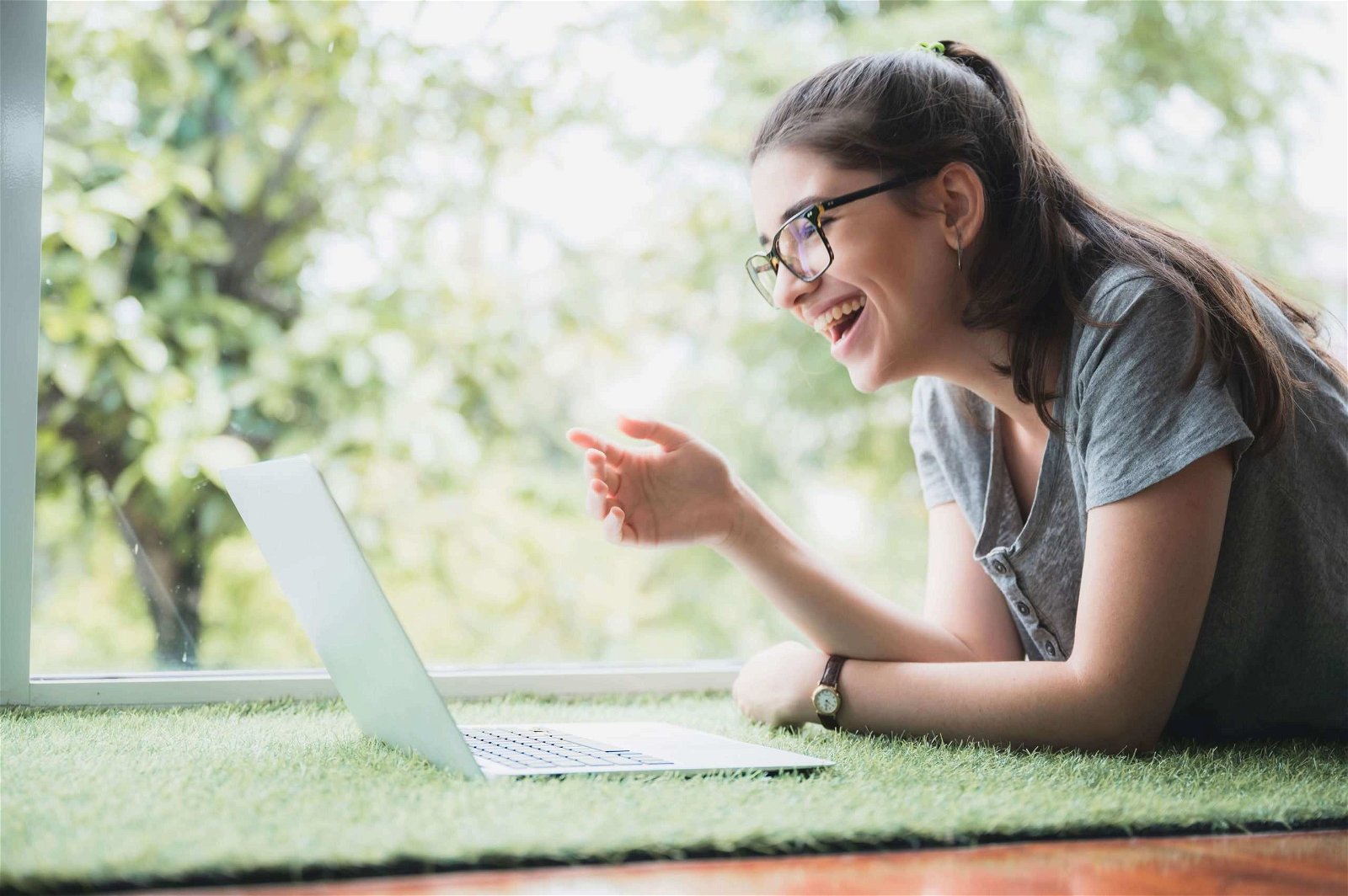 Estudante sentada em relva artificial Estudante sentada em relva artificial